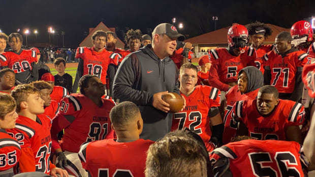 Clinton coach Judd Boswell addressed his team following Friday night's 17-14 win over Tupelo before handing the game ball to kicker Luke Hopkins. (Photo by Tyler Cleveland)
