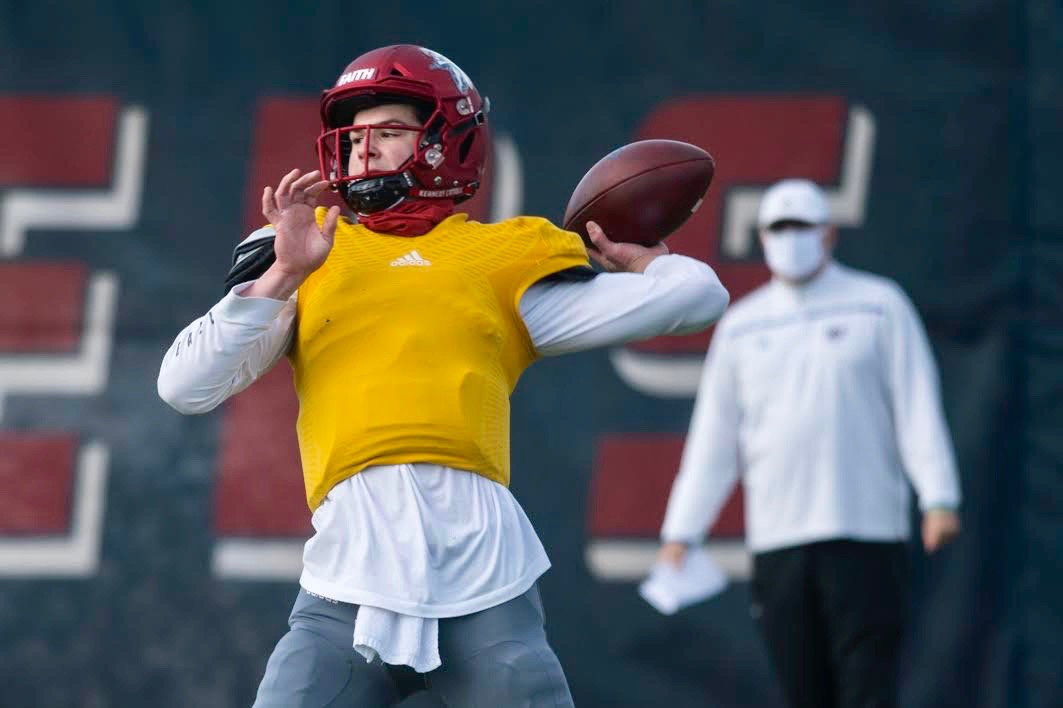 Kennedy Catholic High School quarterback Sam Huard throws a pass as coach Sheldon Cross looks on during practice on Tuesday, March 23, 2021 at Kennedy Catholic High School in Burien, Wash.