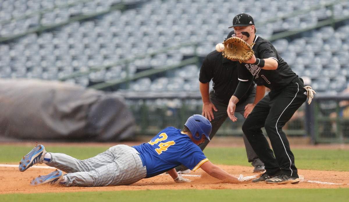 Sumrall's Walker Long (34) dives back to first base as West Lauderdale's Brett Busbea (1) awaits the throw. West Lauderdale and Sumrall played in game 1 of the MHSAA Class 4A Baseball Championship on Friday, June 4, 2021 at Trustmark Park. Photo by Keith Warren