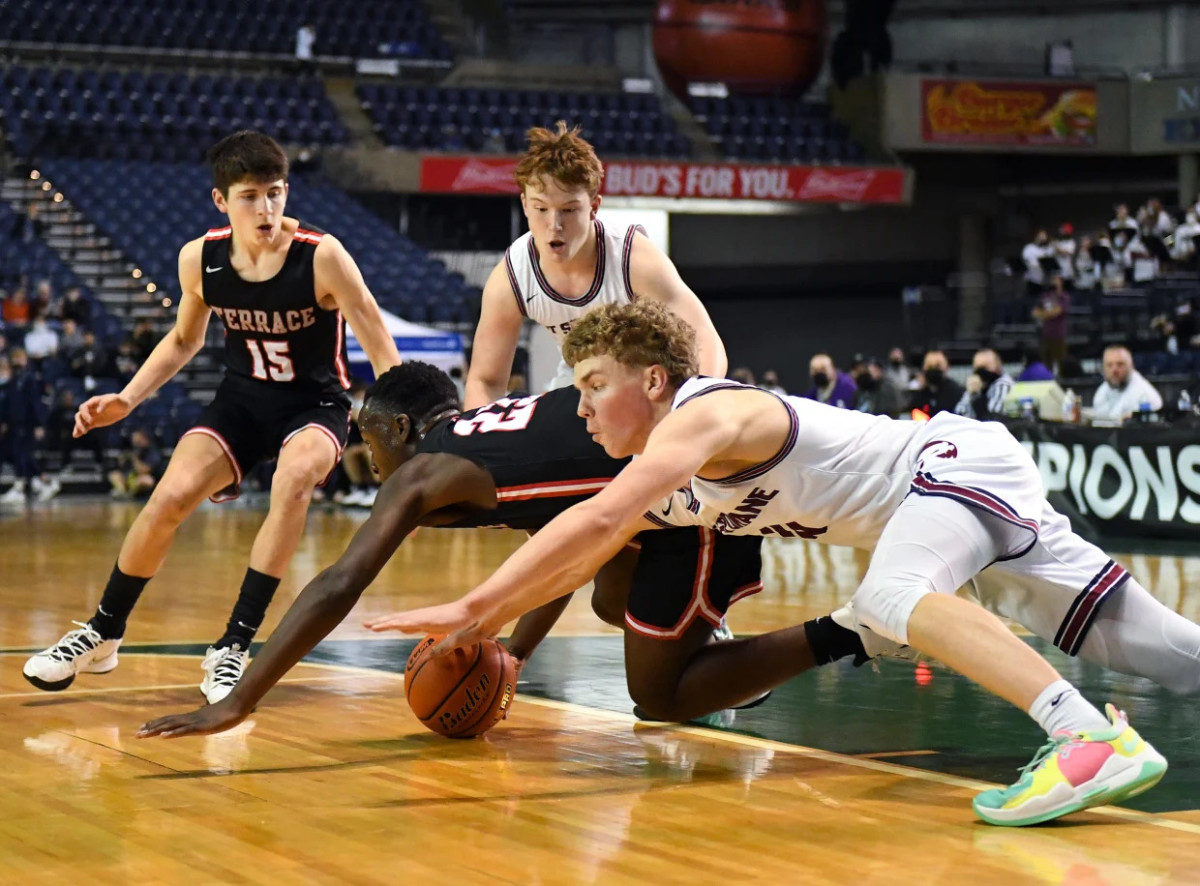 Jeffrey Anyimah (left, No. 23) dives for a loose ball against Mt. Spokane in the 3A state tournament in the Tacoma Dome. 