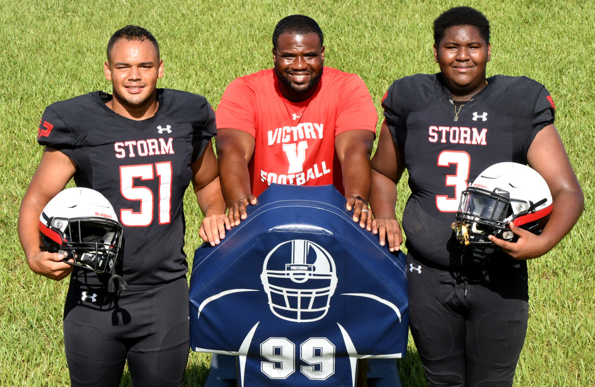 Victory Christian senior Trent Lewis (51) and freshman Jordan Jenkins (3) join head coach Kendrick Stewart (center) at the Storm’s media day in Lakeland.
